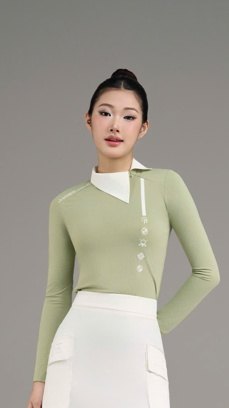 Woman wearing a green top and white skirt with knee-high socks and shoes on a gray background